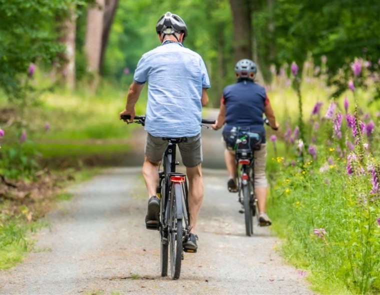 People Riding Bicycles on Dirt Road
